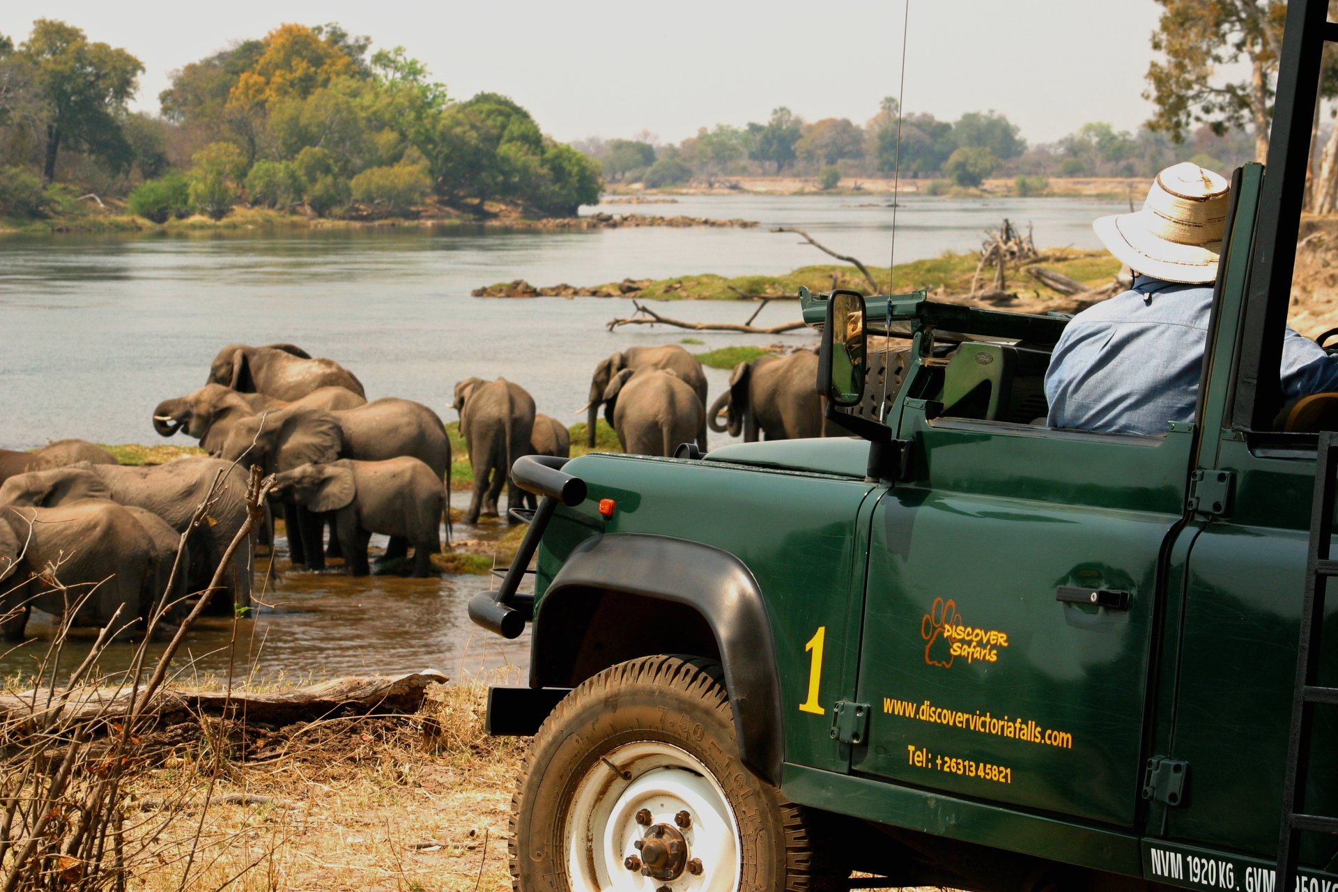 Discover Safaris vehicle with elephants drinking from river